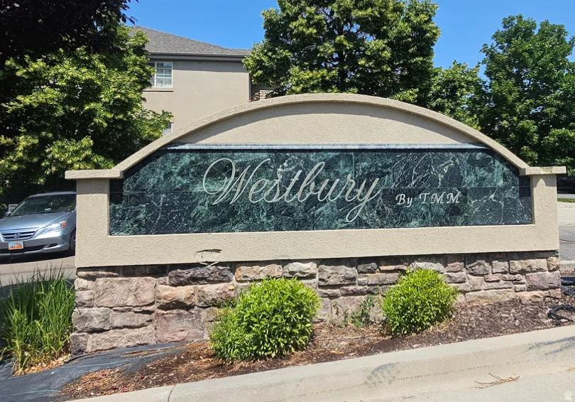 Stone-clad monument sign featuring a green marble-like panel with white script