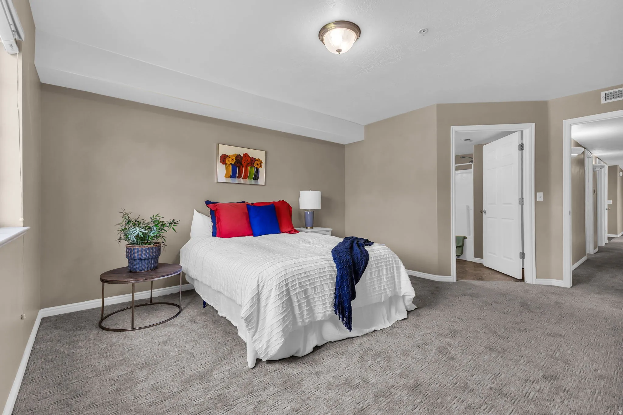 Carpeted room featuring neutral wall tones, white trim, and a window providing natural light