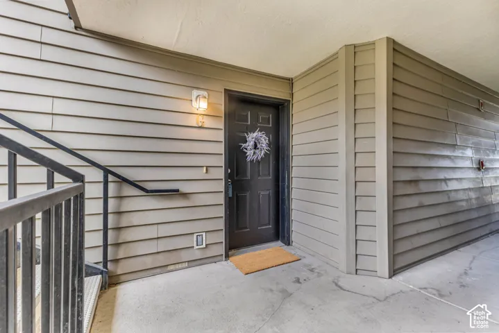 Entryway featuring a paneled door, exterior wall sconce, and horizontal siding