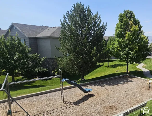 Common area playground featuring a slide, monkey bars, and a spring rider