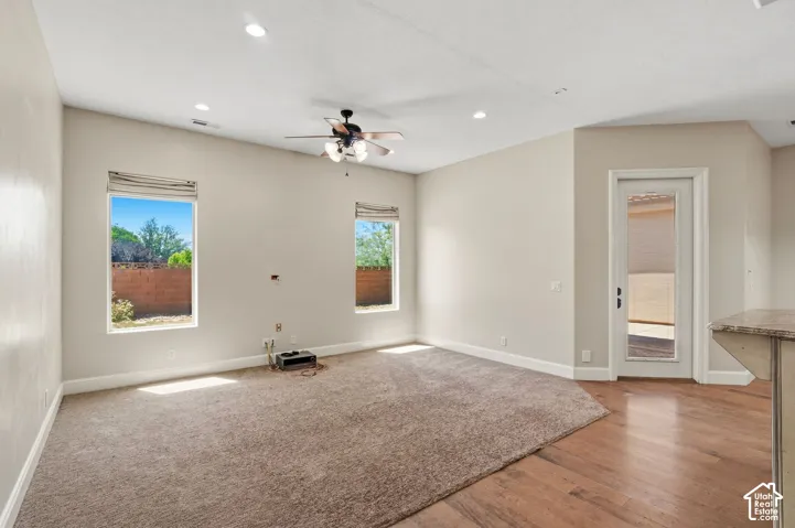 Open-concept living space featuring wood-finish flooring, recessed lighting, and a ceiling fan