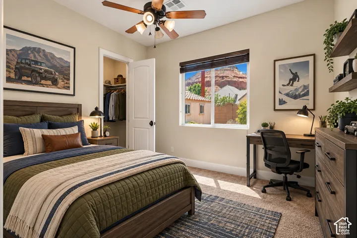 Neutral-toned interior featuring carpeting, a ceiling fan with integrated lighting, a sliding window with wood-slat blinds, and a built-in reach-in closet with a raised-panel door