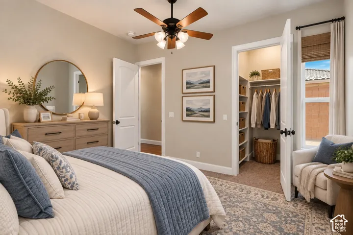 Neutral-toned room featuring a central ceiling fan with integrated lighting, a walk-in closet with built-in shelving, and a single-hung window with a natural woven shade