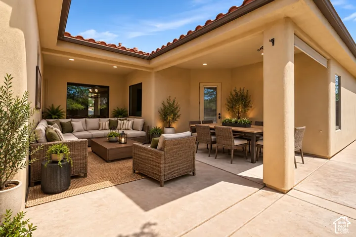 Covered patio featuring a concrete floor, recessed lighting, stucco exterior walls, and a terracotta tile roofline