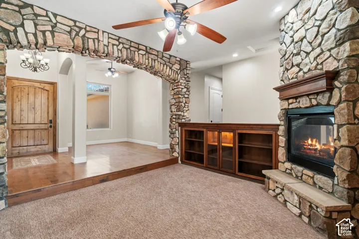 Stone-clad fireplace with a wood mantle and hearth, complemented by a built-in wood cabinetry unit