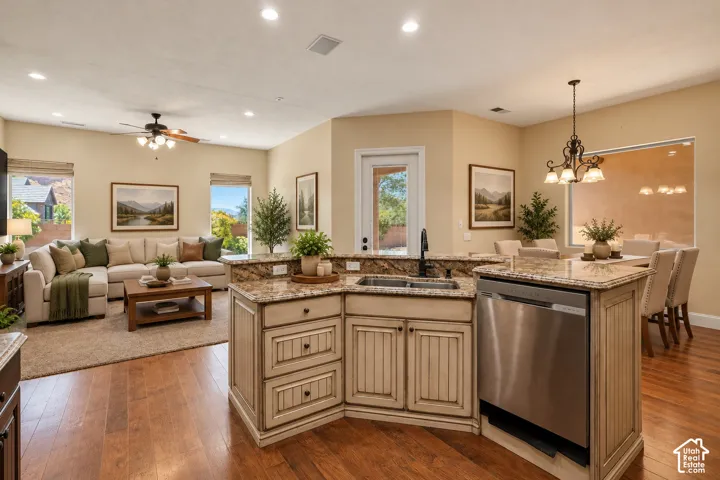 Kitchen island featuring stone countertops, integrated stainless steel dishwasher, and inset cabinetry with a distressed finish