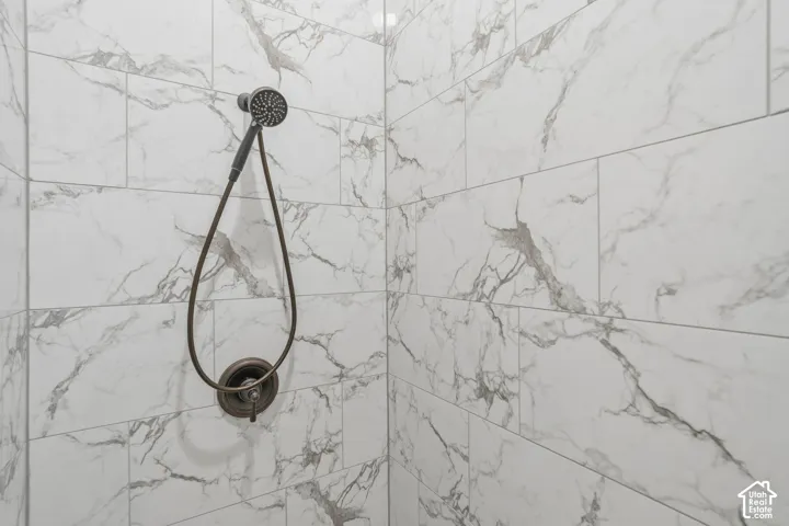 Shower enclosure featuring white marble-look subway tiles