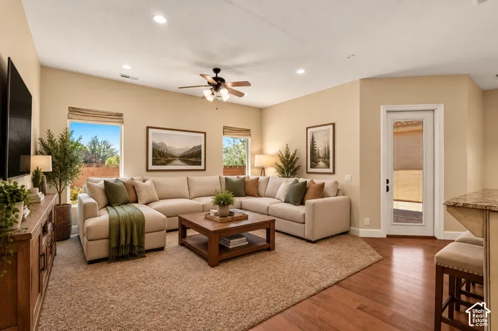 Living area featuring recessed lighting, a ceiling fan with integrated light fixture, wood-finish flooring, and a glass-paneled exterior door