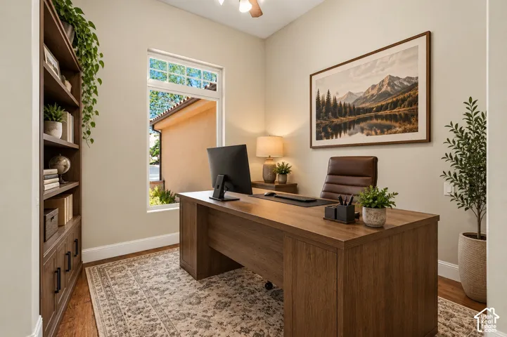 Built-in floor-to-ceiling shelving with lower cabinetry, wood-finish flooring, and natural light from a vertical window