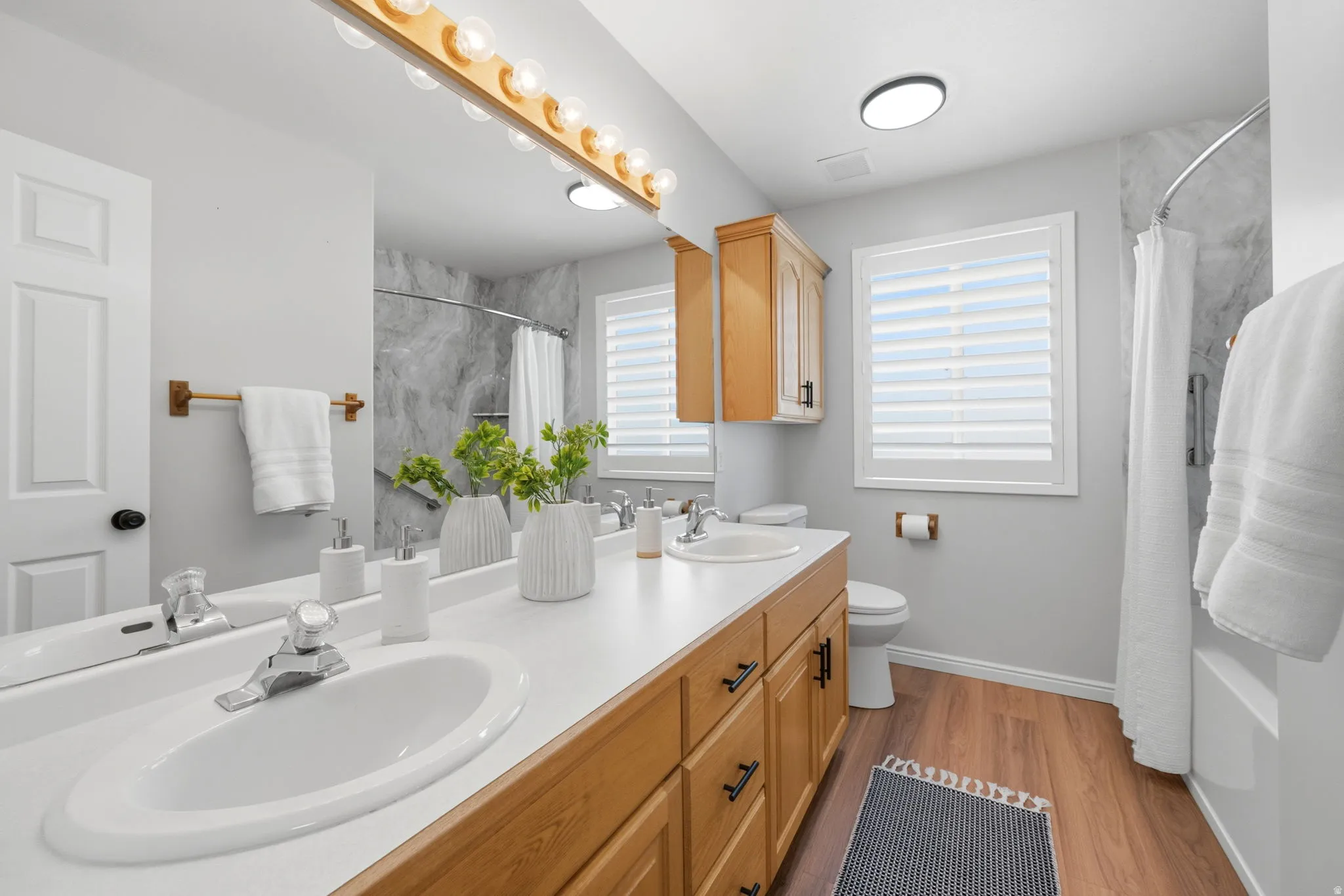 Dual-sink vanity with wood-finish cabinetry and white countertops