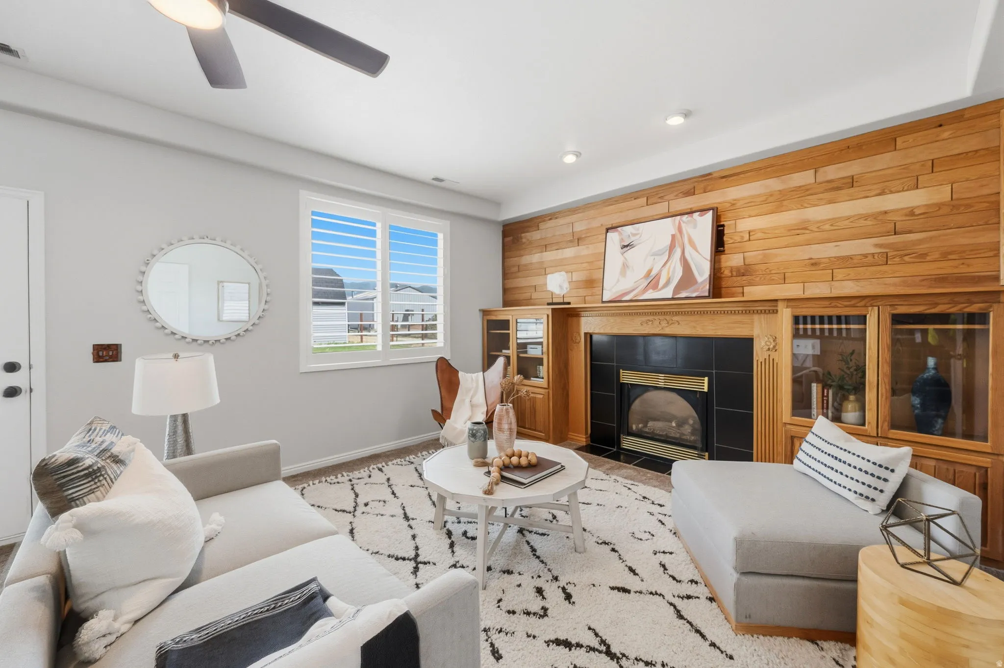 Living area featuring a fireplace with a black tile surround, a wood mantle, and built-in cabinetry