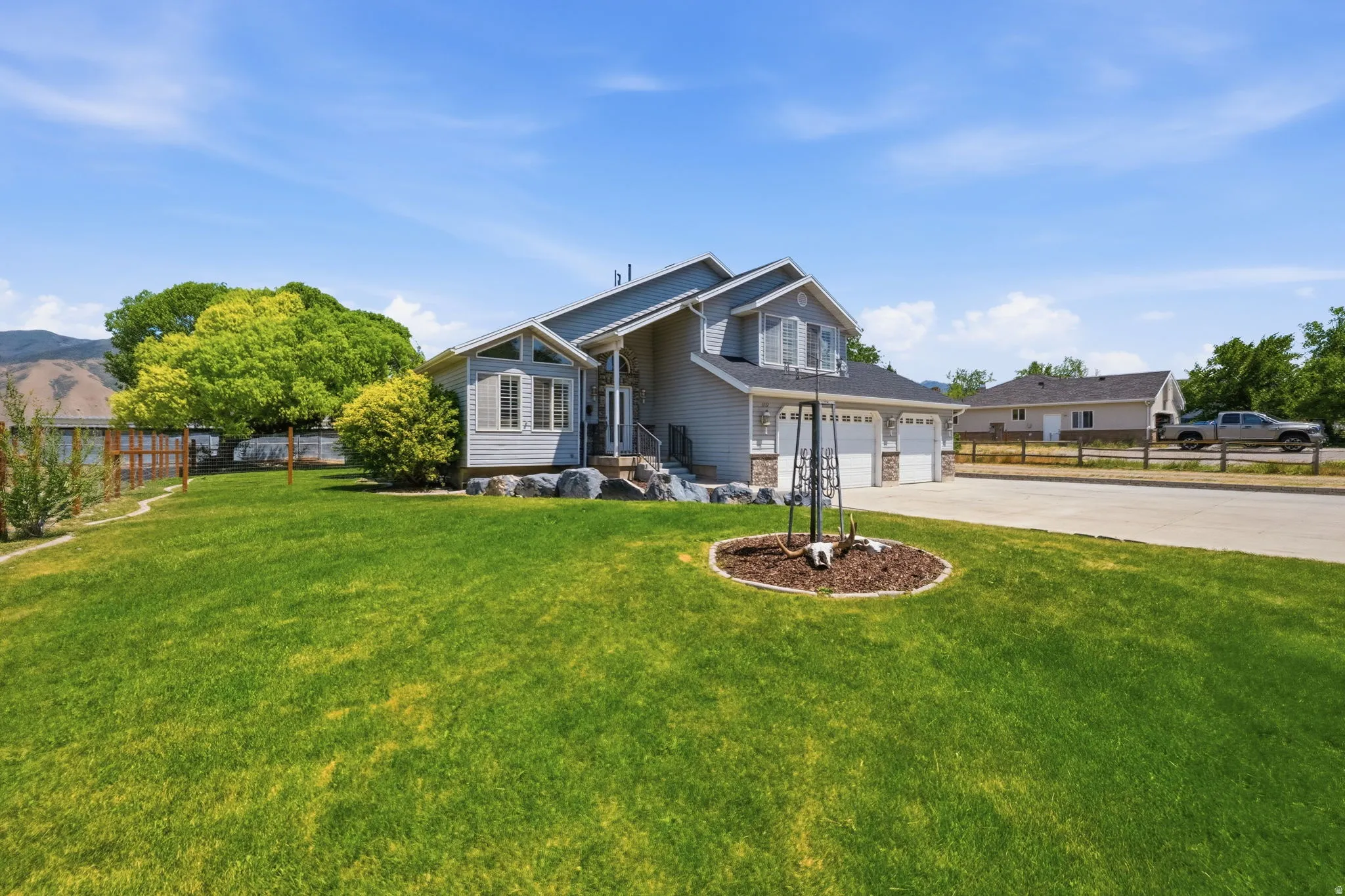 Two-story residence featuring light gray siding, white trim, and a dark shingled roof