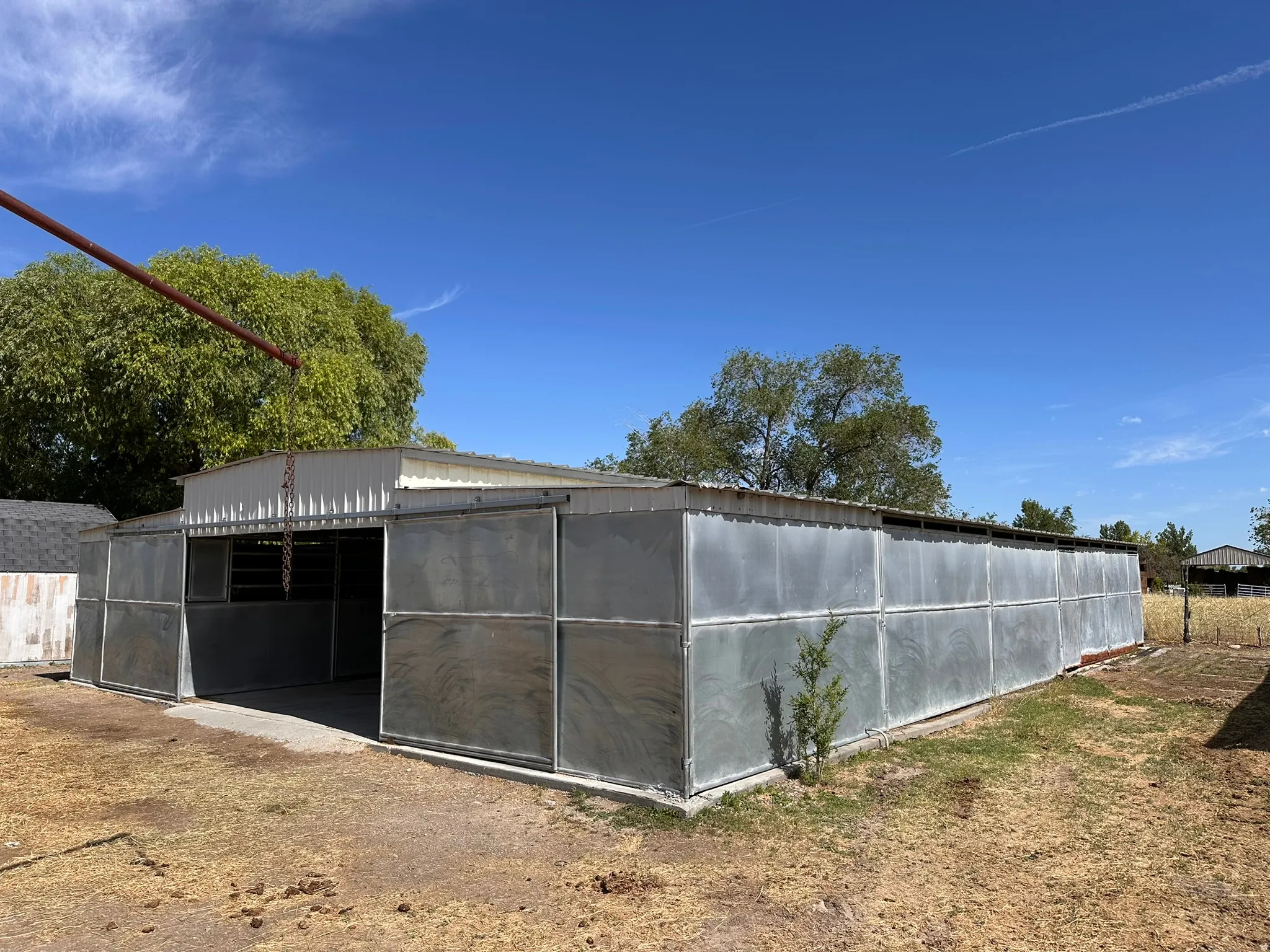 Metal-clad outbuilding with an open-front section and a full-length metal roof