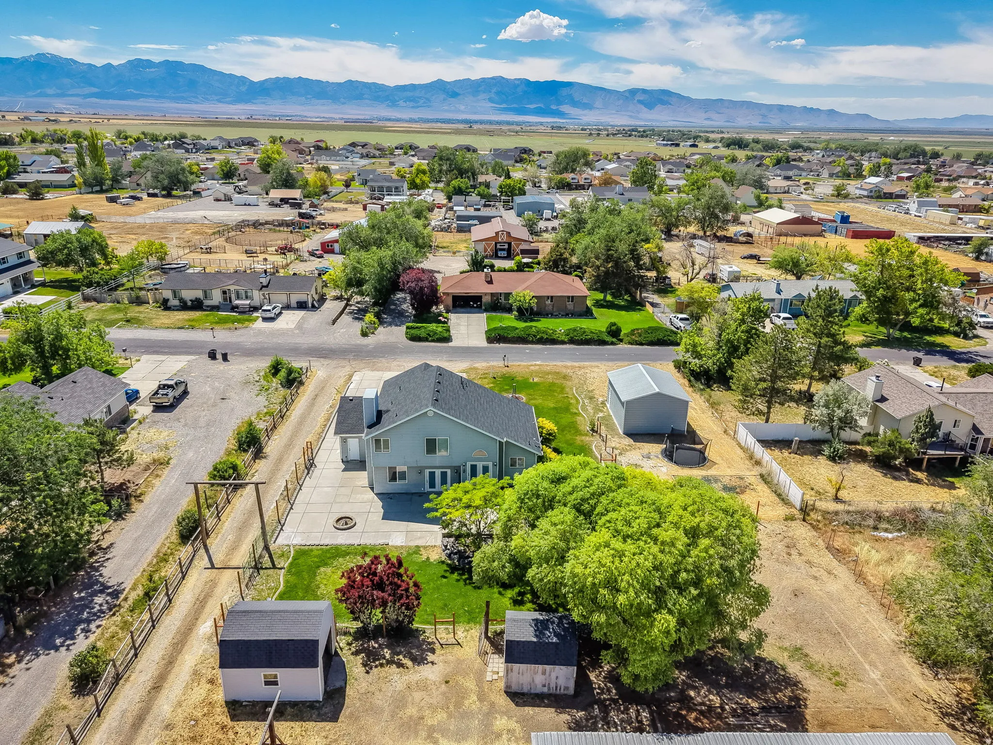 Aerial perspective showcasing a residential property with surrounding neighborhood and distant mountains