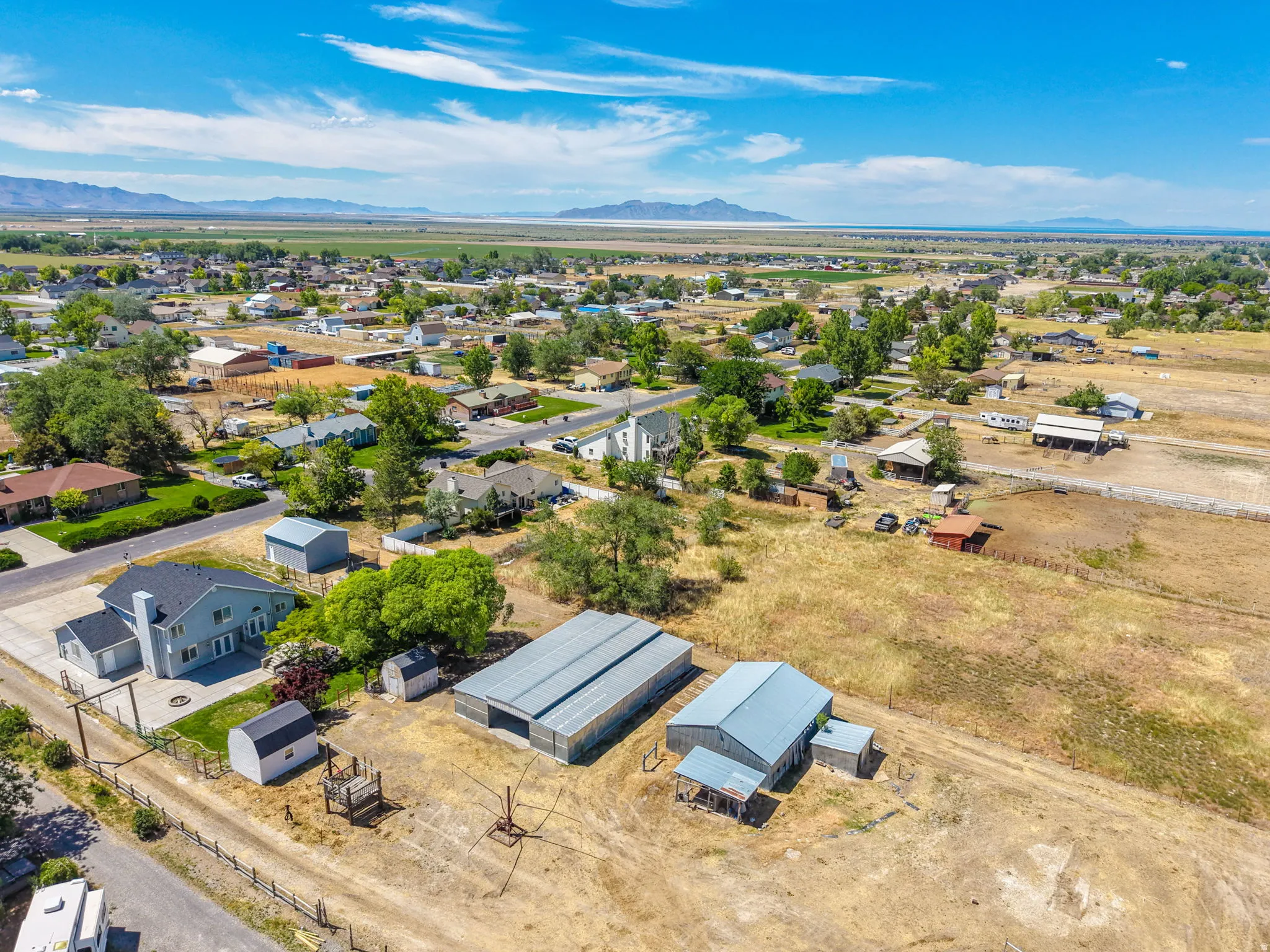 Expansive property featuring multiple outbuildings, including a large metal barn structure and smaller storage sheds