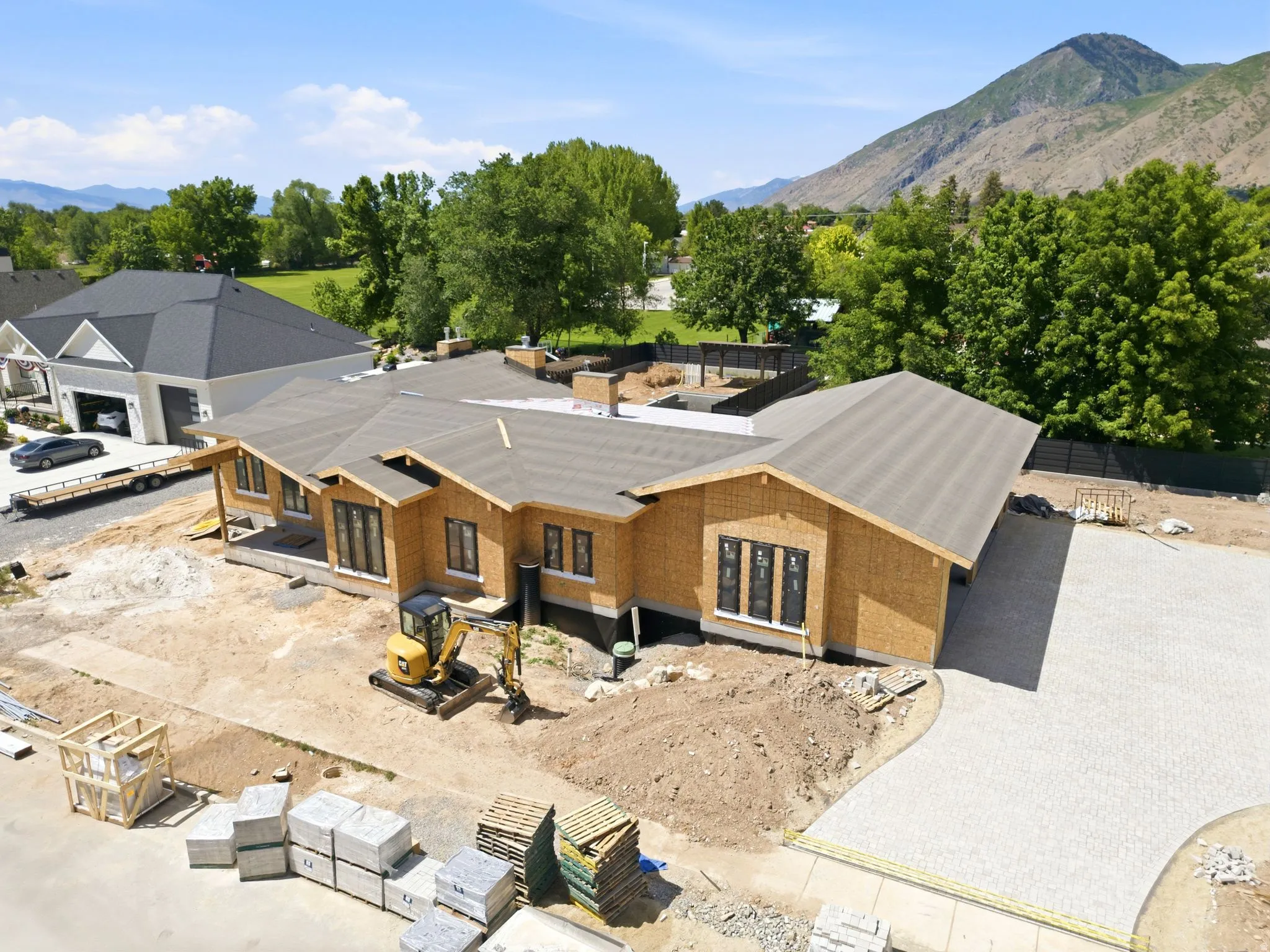 New construction property featuring a fully paved driveway with premium paver stone, offering exceptional curb appeal and a grand approach to the home, all leading to an oversized 4-car garage with ample space for vehicles, storage, and recreational equip