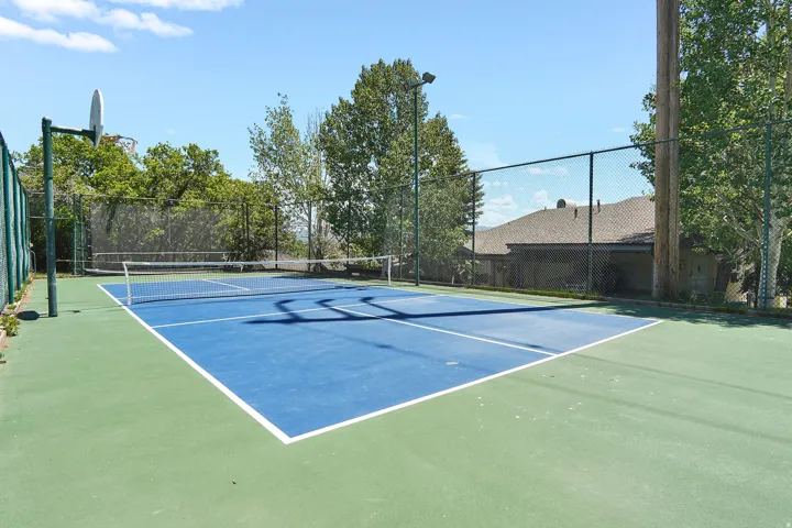 Private outdoor Pickleball court featuring a blue and green playing surface