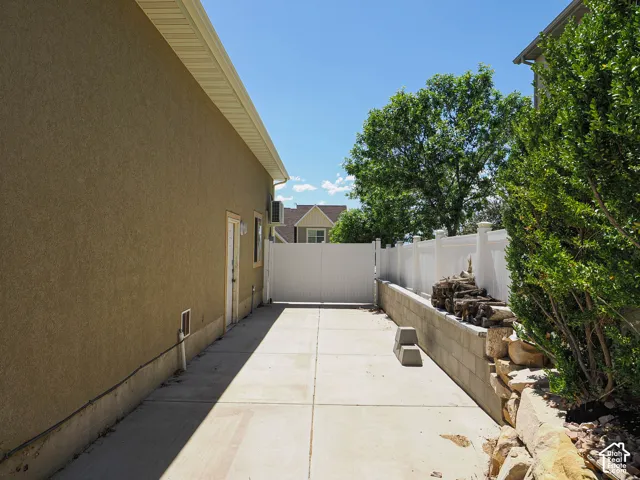 Exterior stucco siding with a white vinyl fence