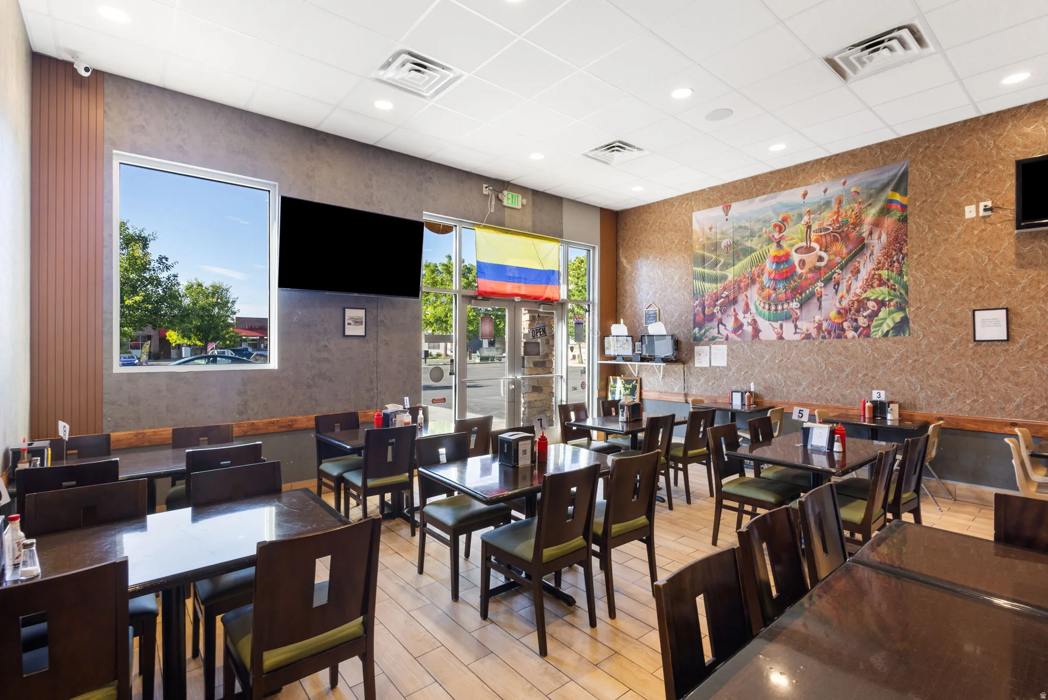 Commercial interior featuring extensive dining area with multiple tables and chairs, textured wall finishes, and recessed ceiling lighting