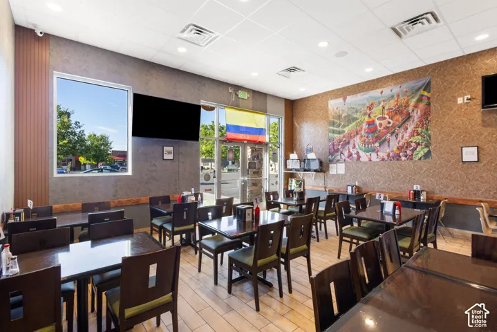 Commercial interior featuring extensive dining area with multiple tables and chairs, textured wall finishes, and recessed ceiling lighting