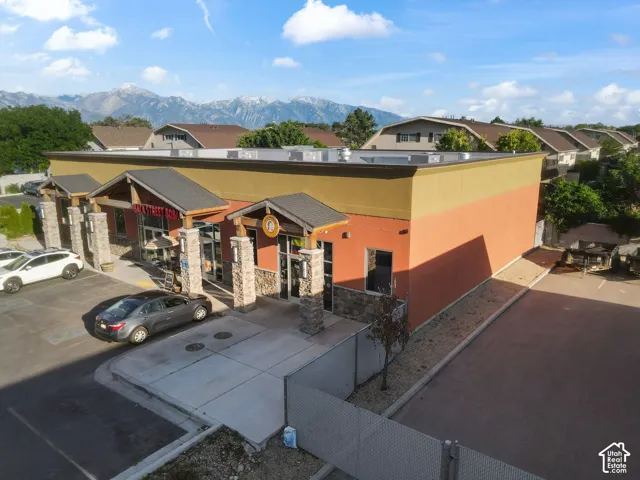 Commercial building featuring a flat roofline, stucco exterior, and prominent stone columns
