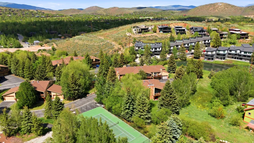 Aerial perspective showcasing a residential community nestled among mature trees and rolling hills