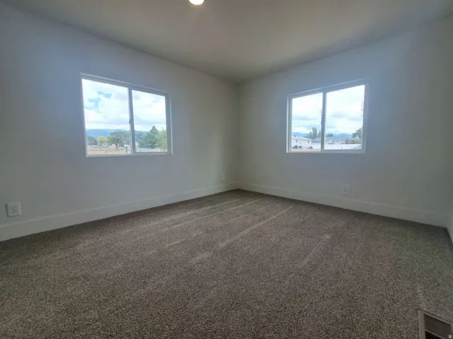 Neutral paint palette with carpet flooring and two windows
