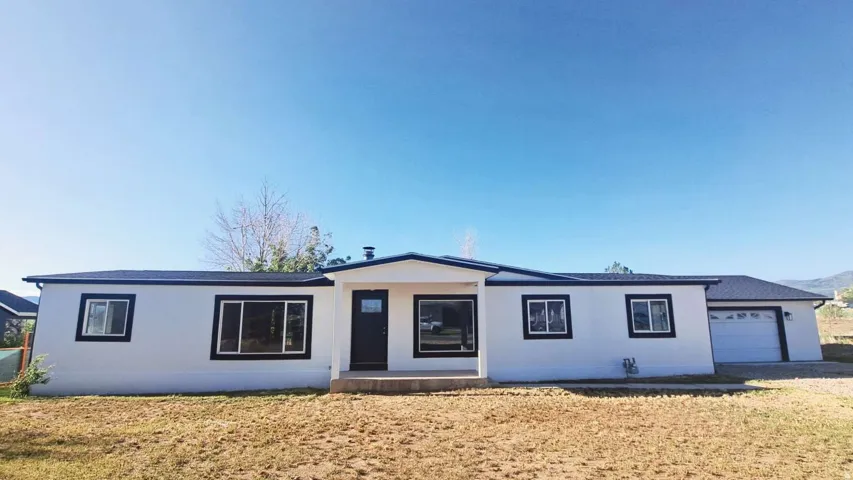 White exterior with dark trim and a dark entry door