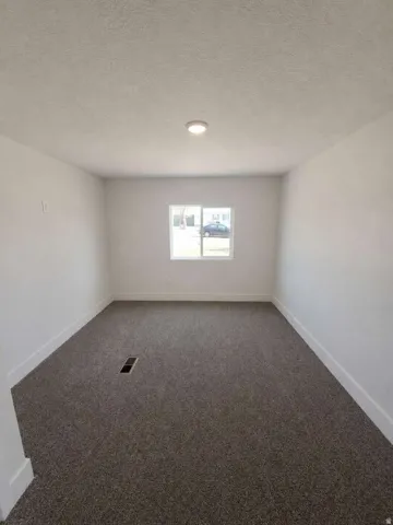 Recessed ceiling lighting, crisp white walls, and a single window with white trim