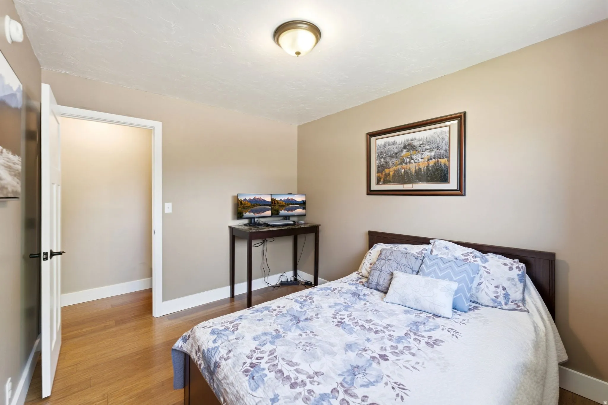 Bedroom featuring wood-finish flooring, neutral wall tones, and white trim