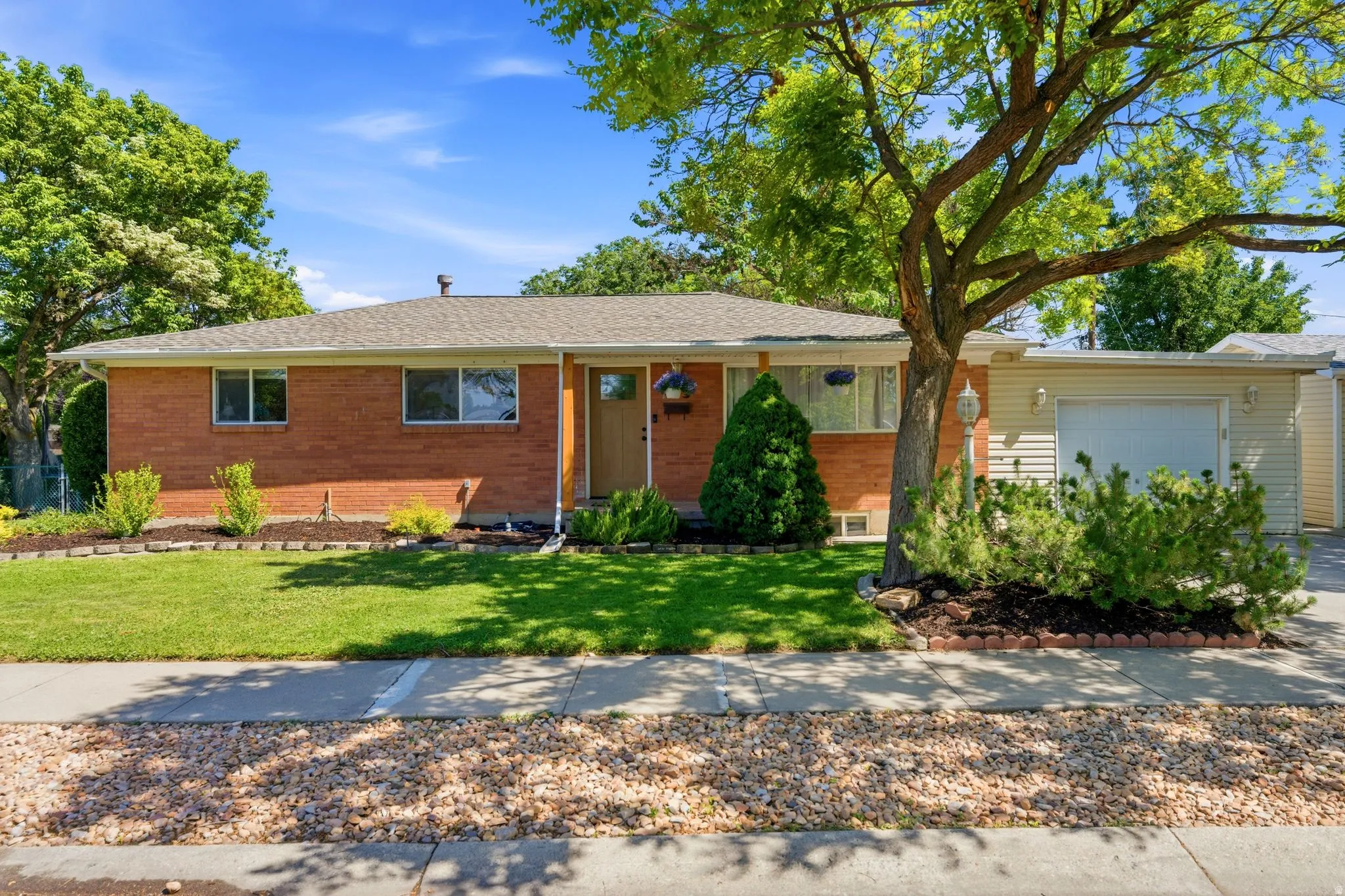 Brick exterior featuring a front lawn and paved driveway