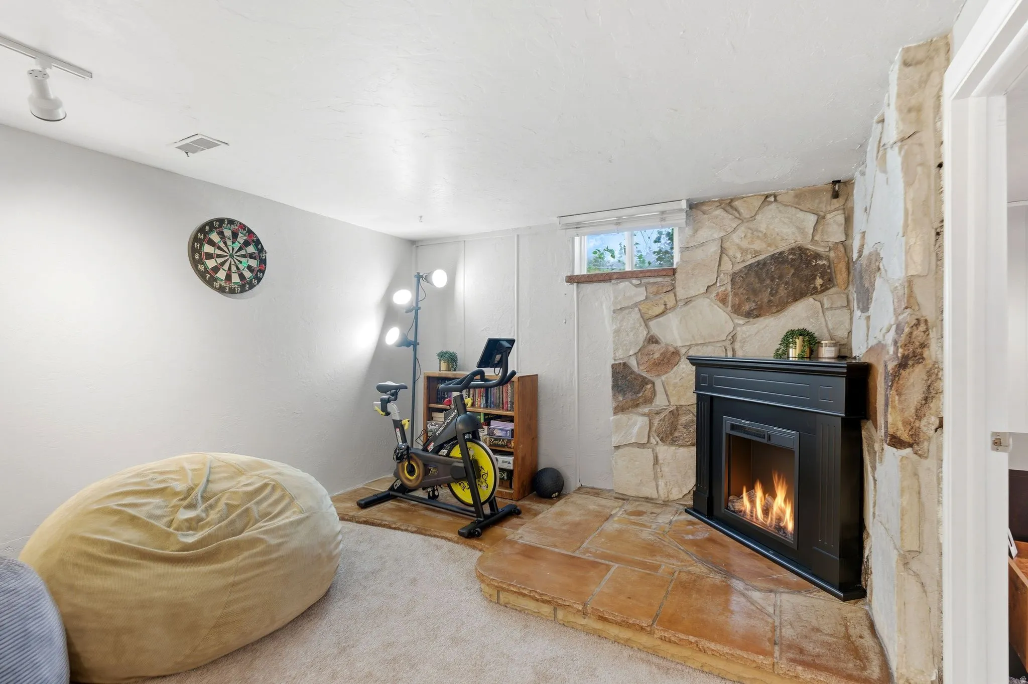 Stone accent wall featuring a black fireplace with a mantel