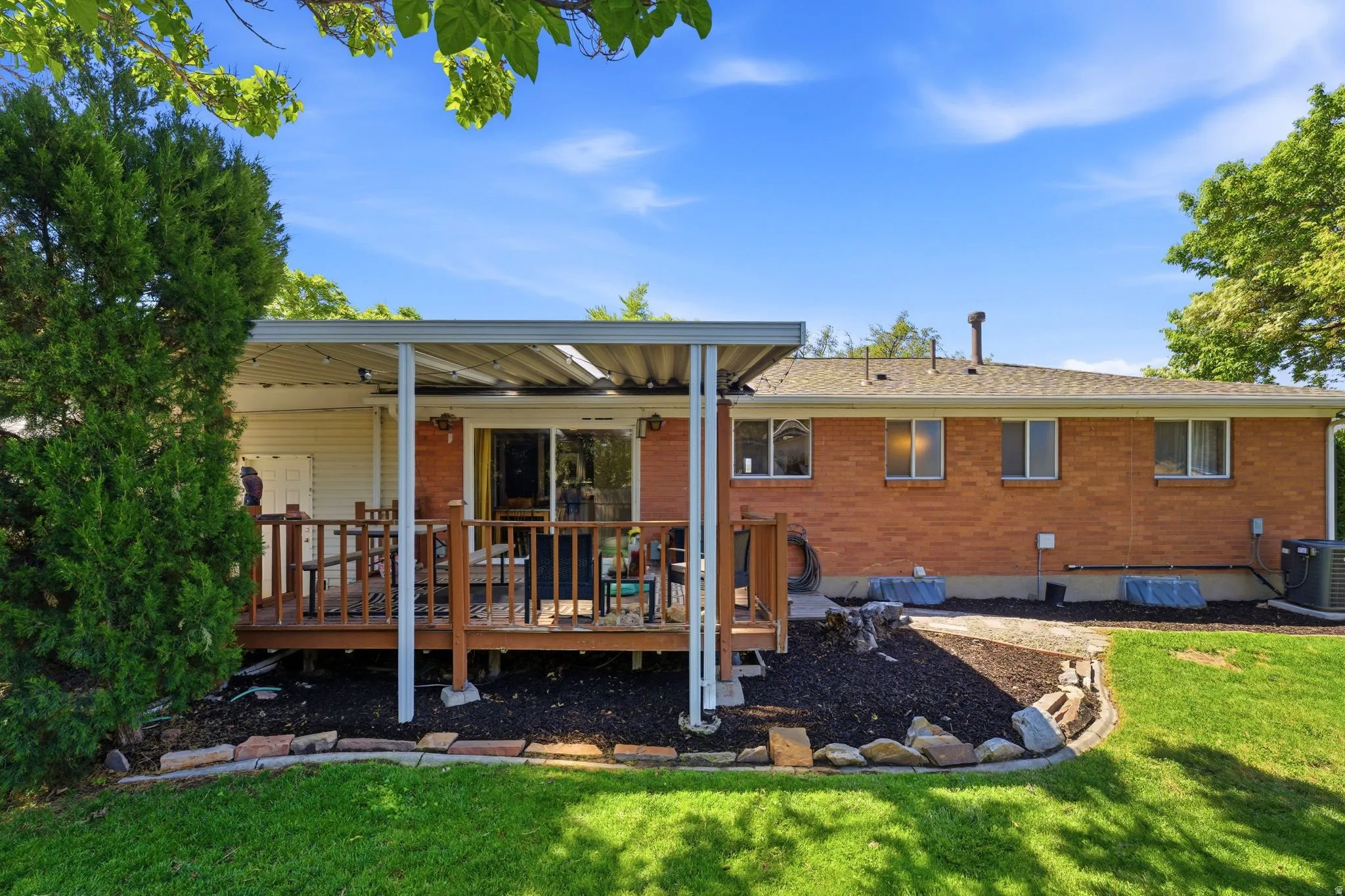 Expansive outdoor deck with a slatted privacy railing, covered by a metal patio canopy