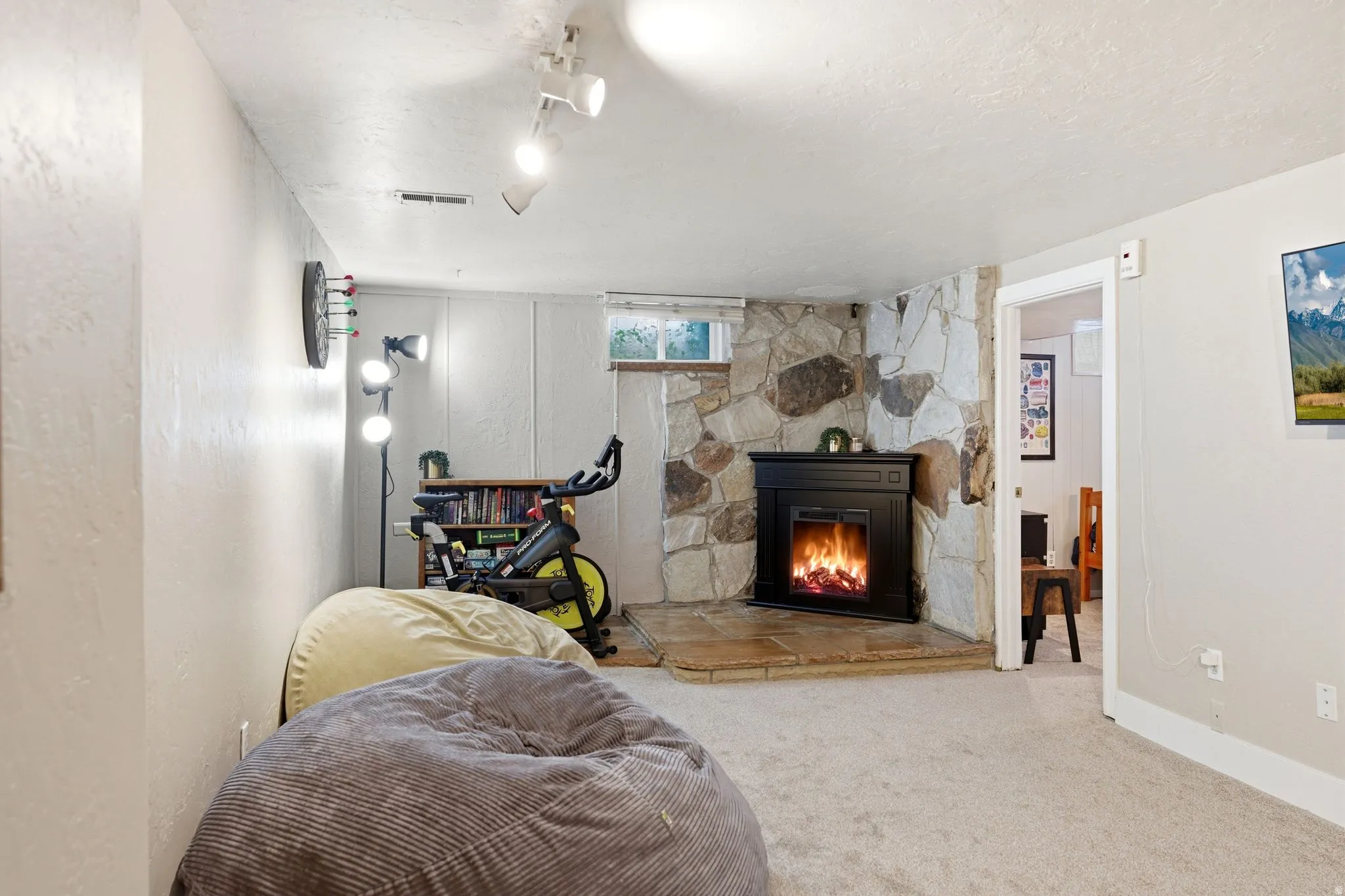 Stone accent wall featuring a black electric fireplace with a hearth