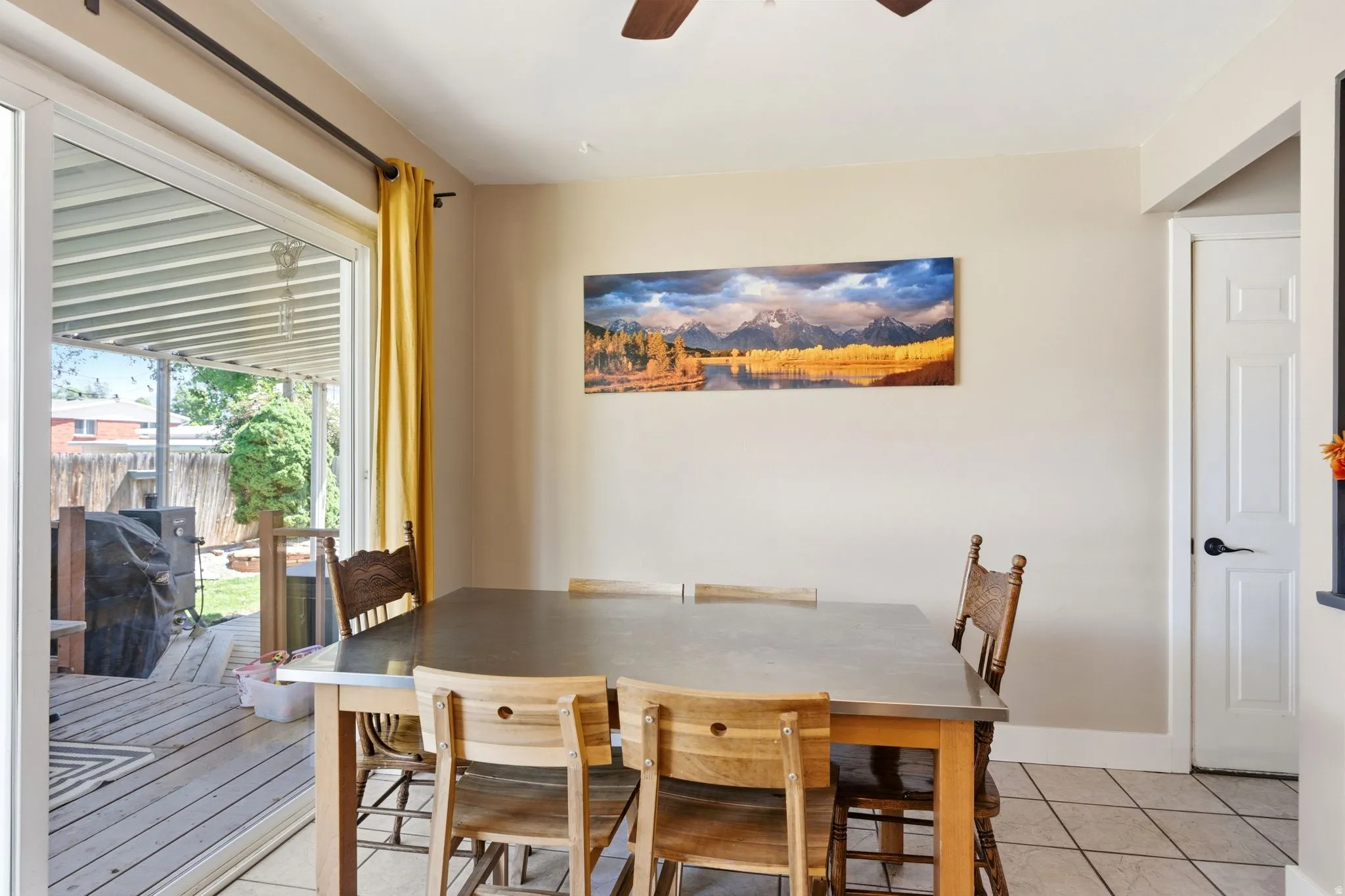 Dining area featuring a sliding glass door, patio access, tiled flooring, a ceiling fan, and a paneled interior door