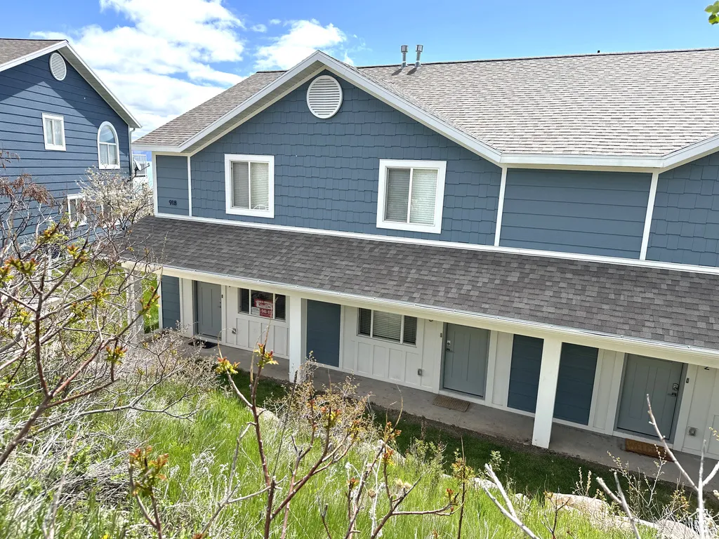 Multi-unit dwelling featuring blue horizontal and shake siding, white trim, and a shingled roof