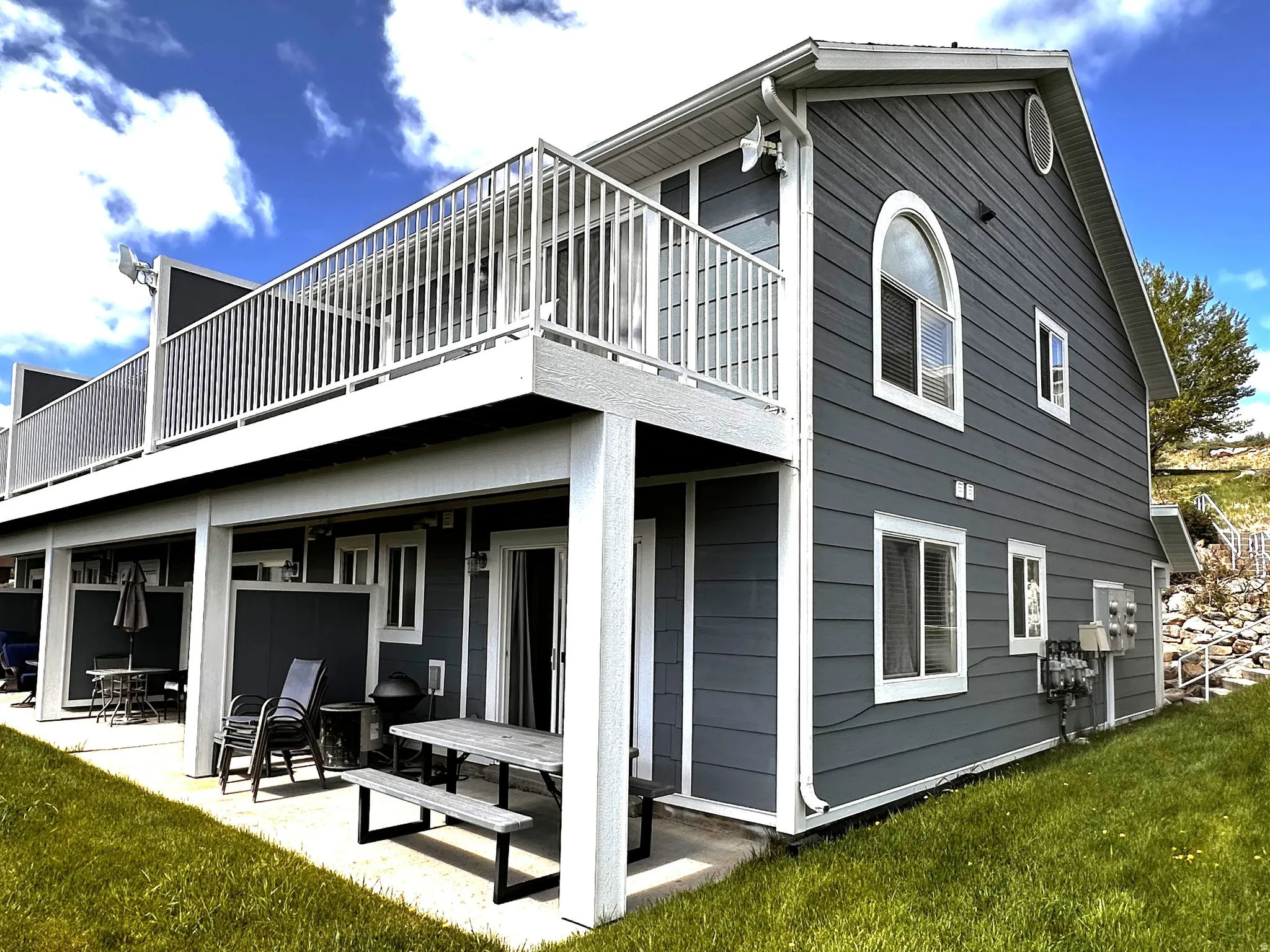 Two-story property featuring dark grey horizontal siding with white trim