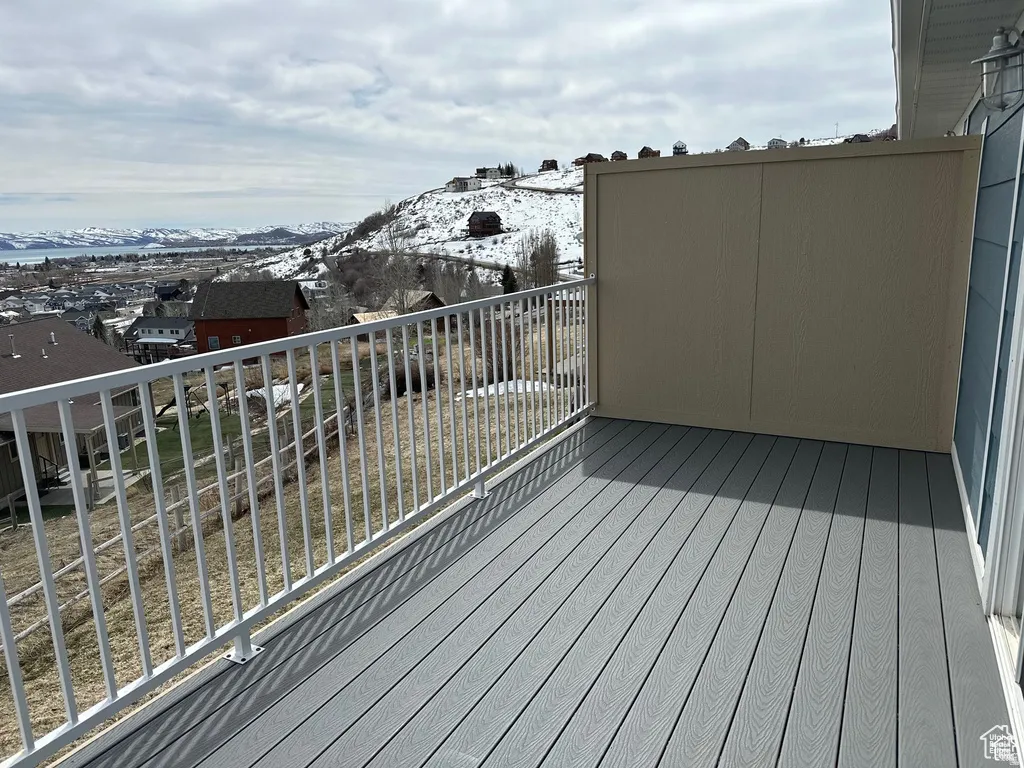 Deck featuring composite decking, white railing, and a privacy wall