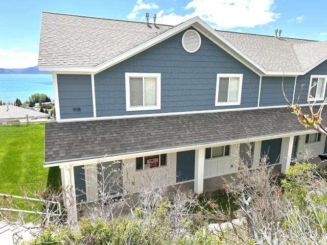 Multi-level exterior featuring blue shingle and lap siding, white trim, and a prominent gable vent