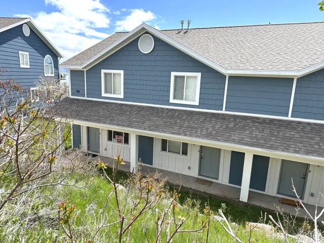 Multi-unit dwelling featuring blue horizontal and shake siding, white trim, and a shingled roof