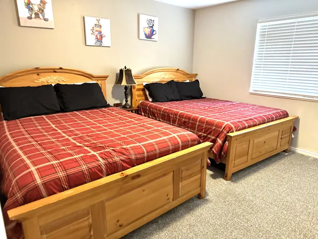 Bedroom featuring neutral wall color, light-toned carpet, and a window with blinds