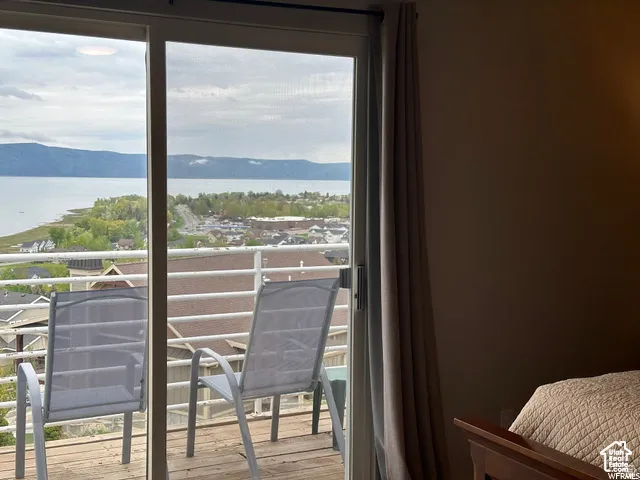 Sliding glass doors opening to a private balcony with a white railing and wooden decking