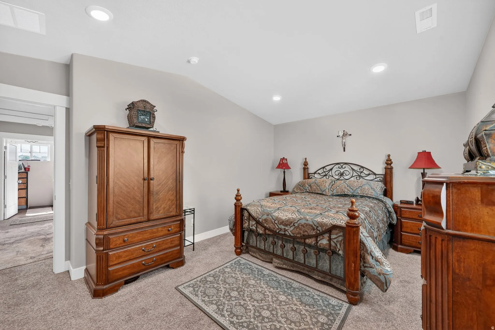 Carpeted bedroom featuring recessed lighting, neutral wall tones, and an arched doorway