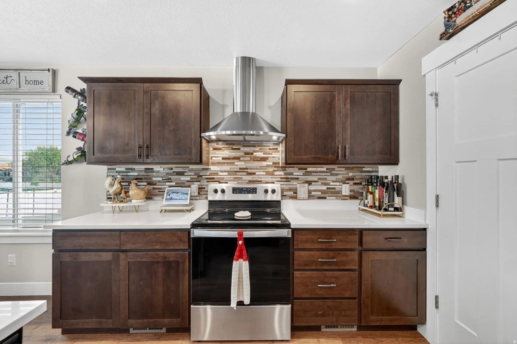Contemporary kitchen featuring dark wood cabinetry, white countertops, and a tiled backsplash