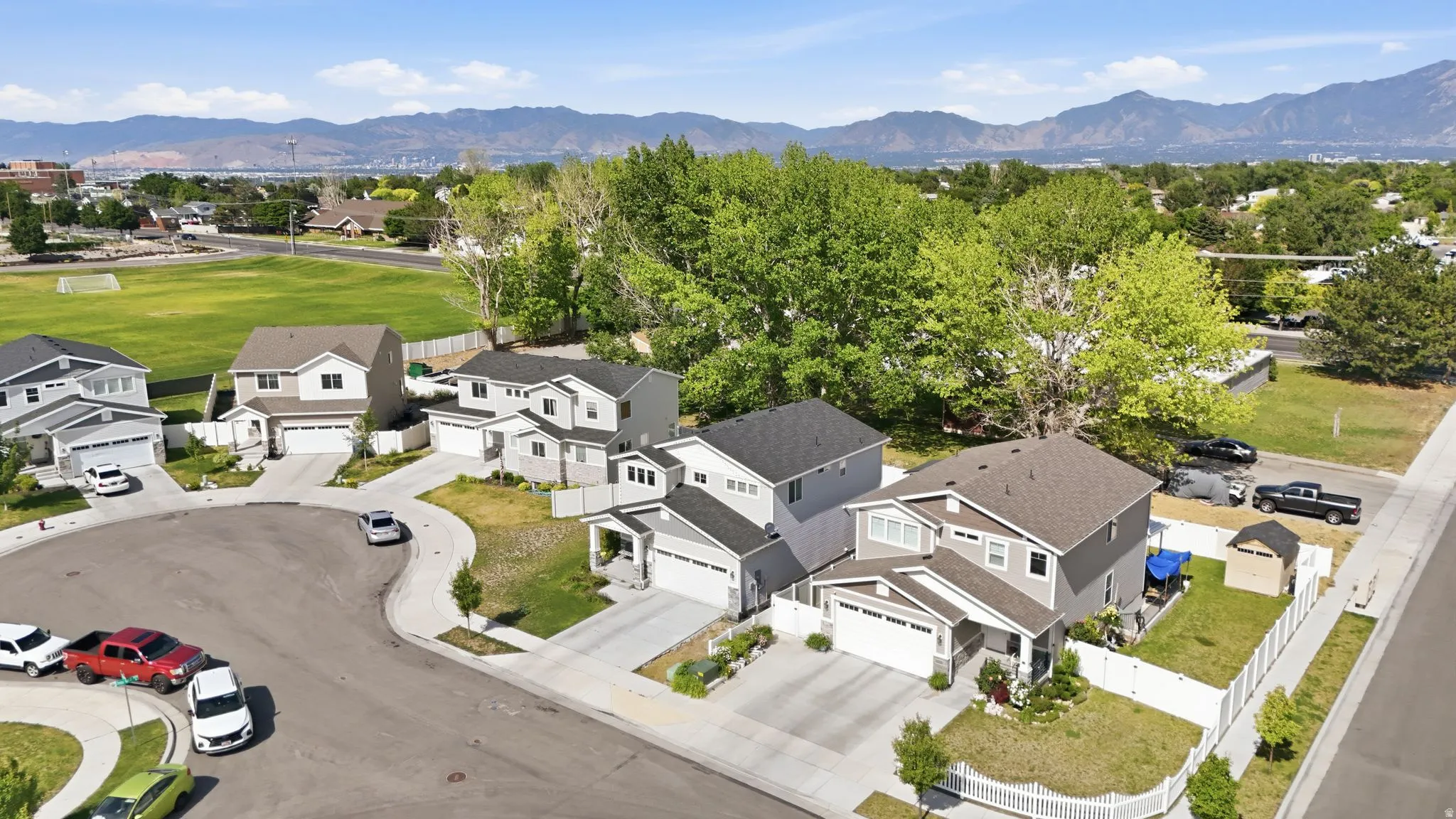 Residential street with modern homes, concrete driveways, and landscaped yards