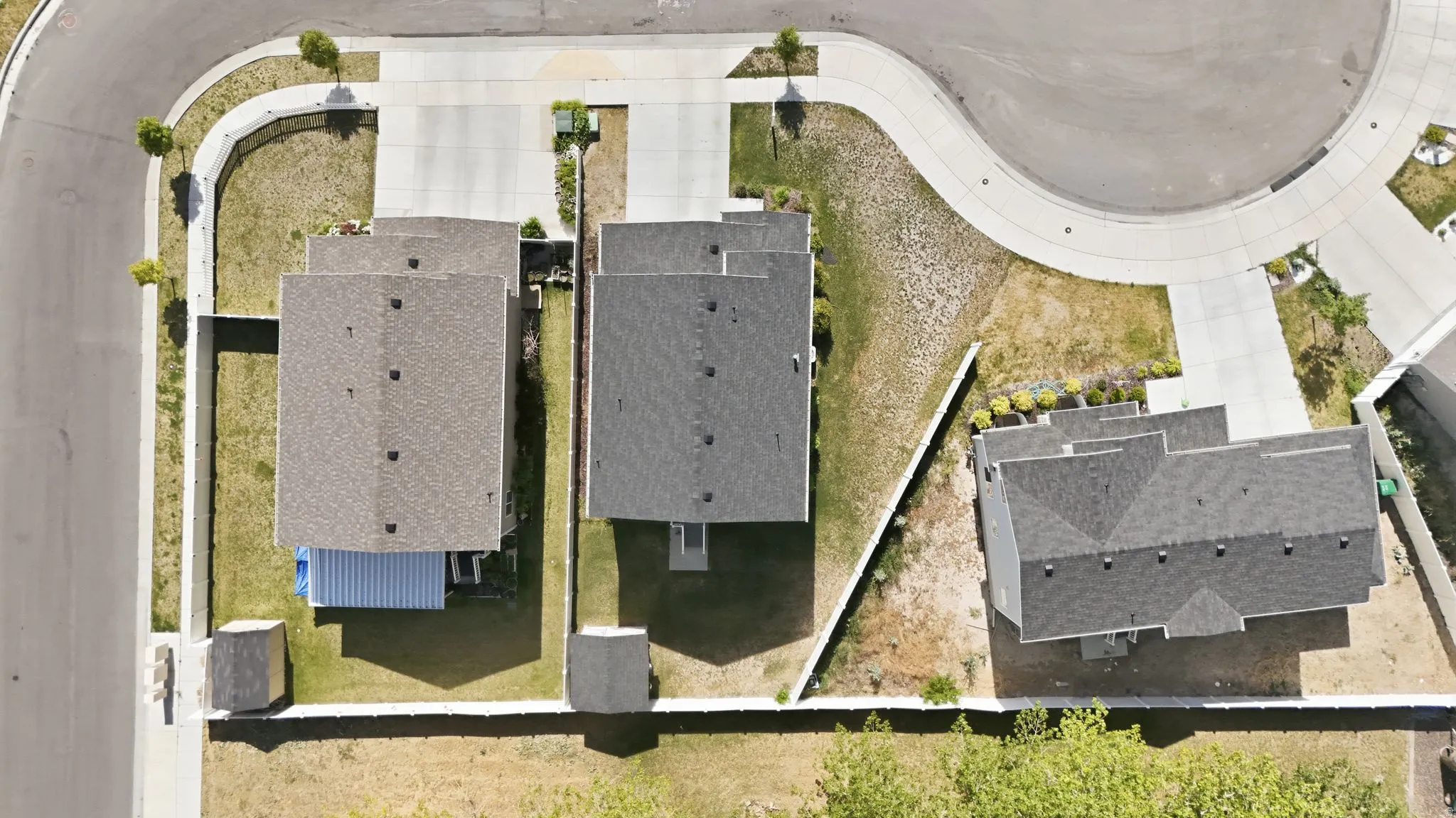 Aerial perspective showcasing residential properties with gray shingle roofing and concrete driveways