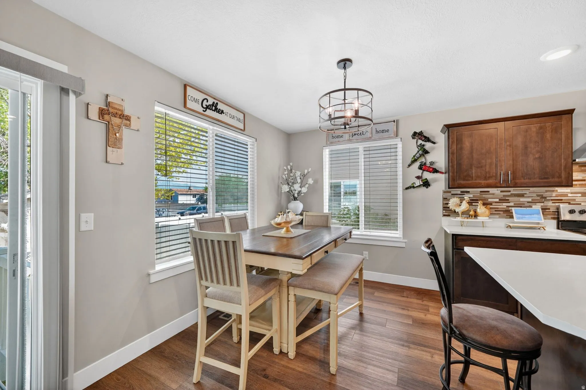 Dining area featuring wood-finish flooring, two window units, and a sliding glass door