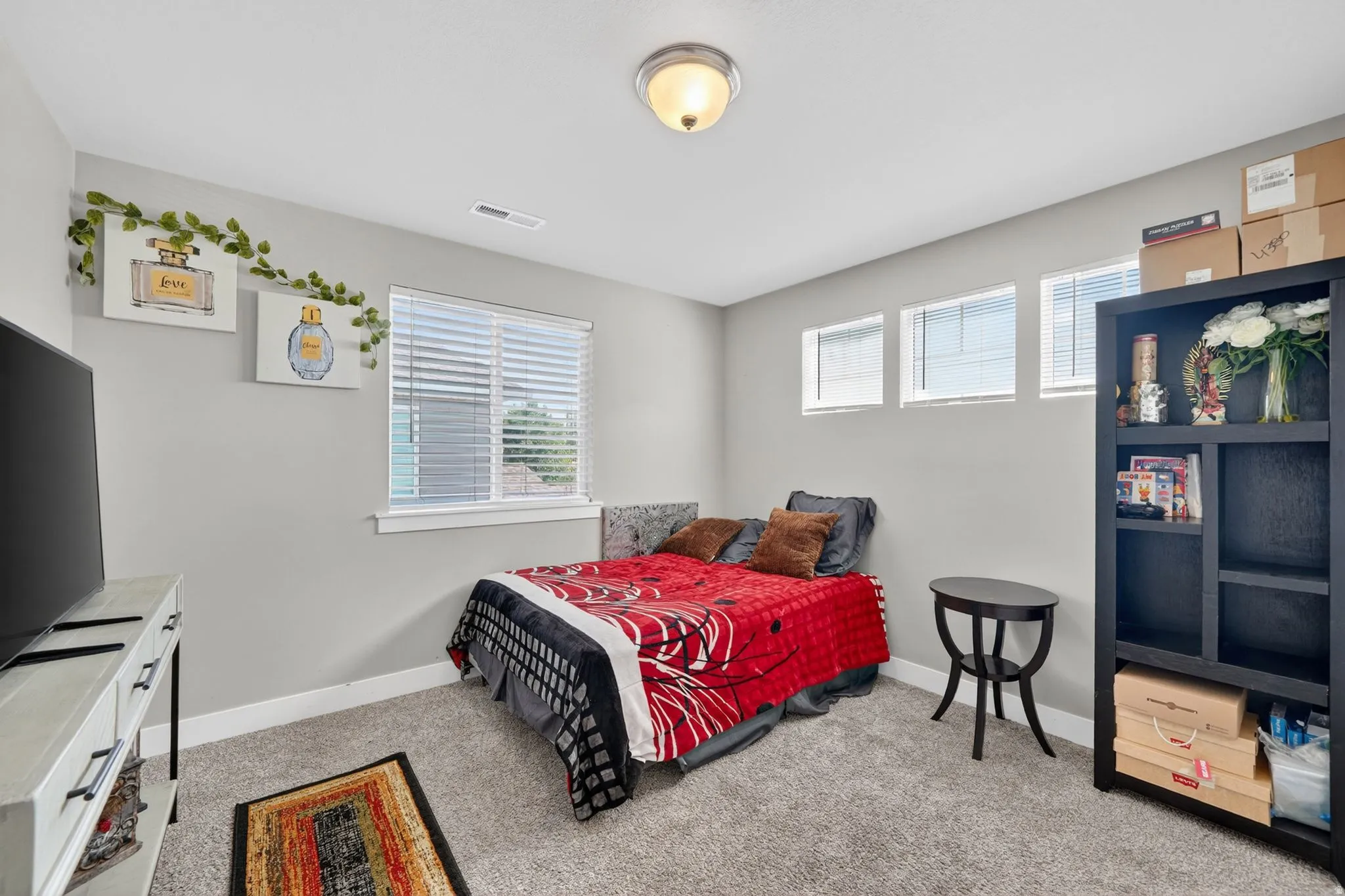 Carpeted room featuring light gray walls, a window with blinds, three upper transom windows, and a flush mount ceiling light