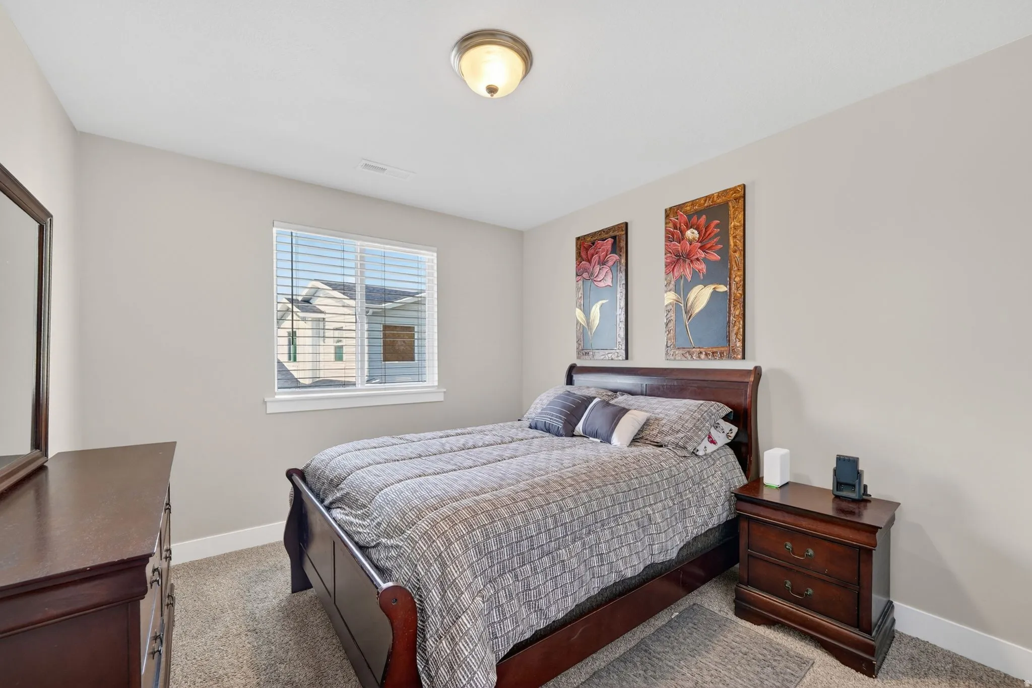 Bedroom featuring neutral-toned walls, a single window with blinds, and carpeted flooring