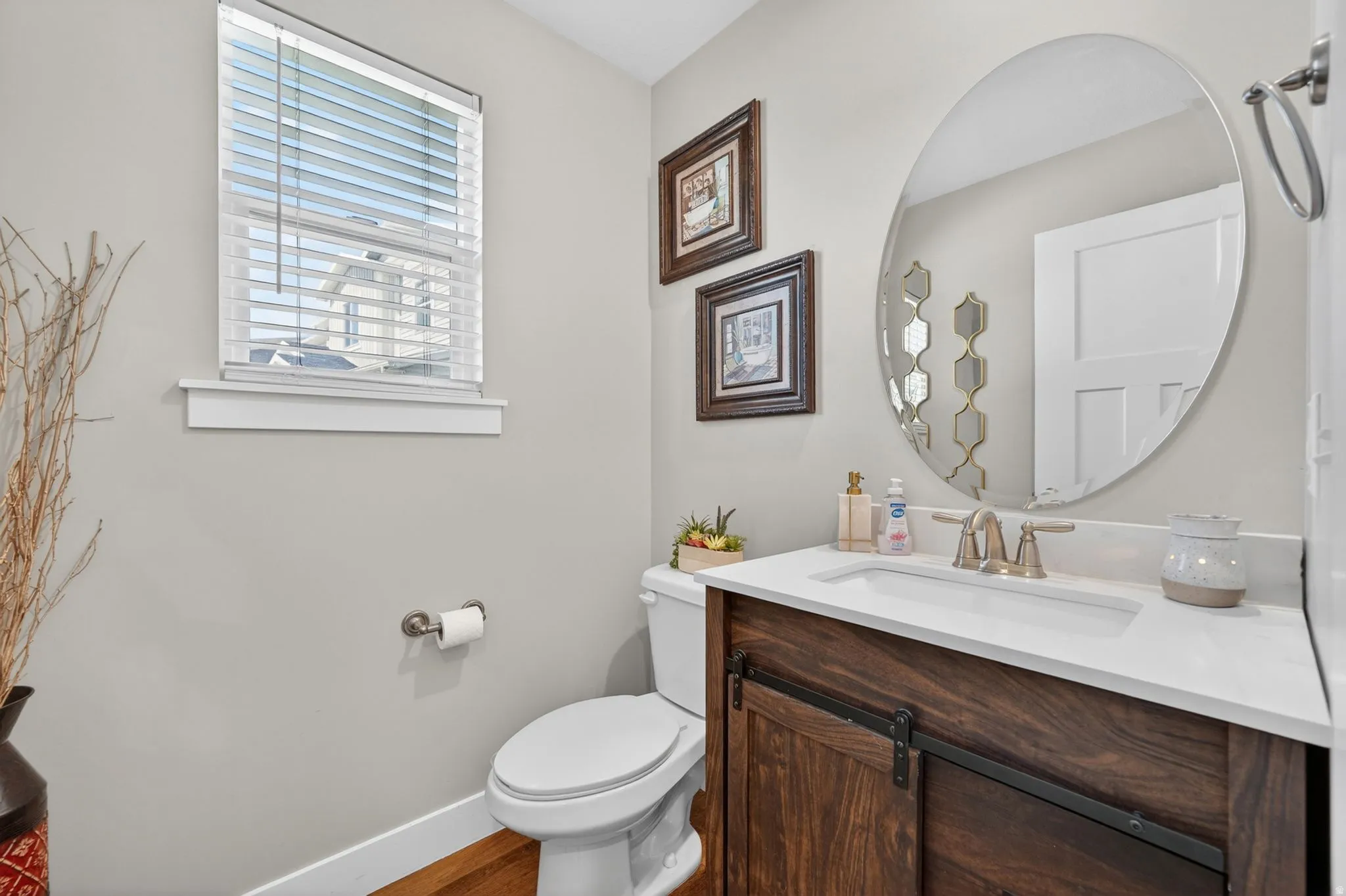 Powder room featuring a wood-finish vanity with a white countertop and undermount sink